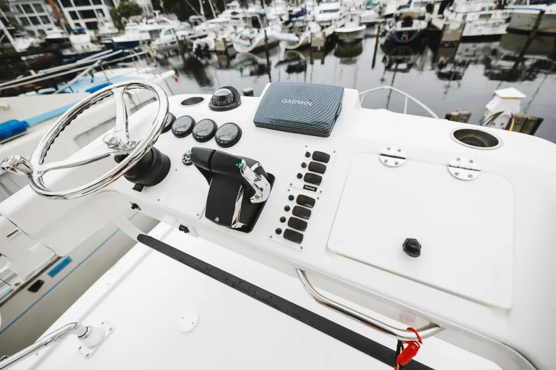 Slide: The Image of Control panel of a 2008 Everglades 350LX boat with steering wheel and Garmin device. - 42