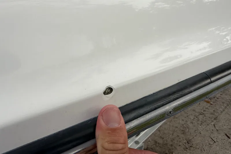 Slide: The Image of Close-up of a 2006 ShearWater Z2200 boat with a small hull damage. - 19