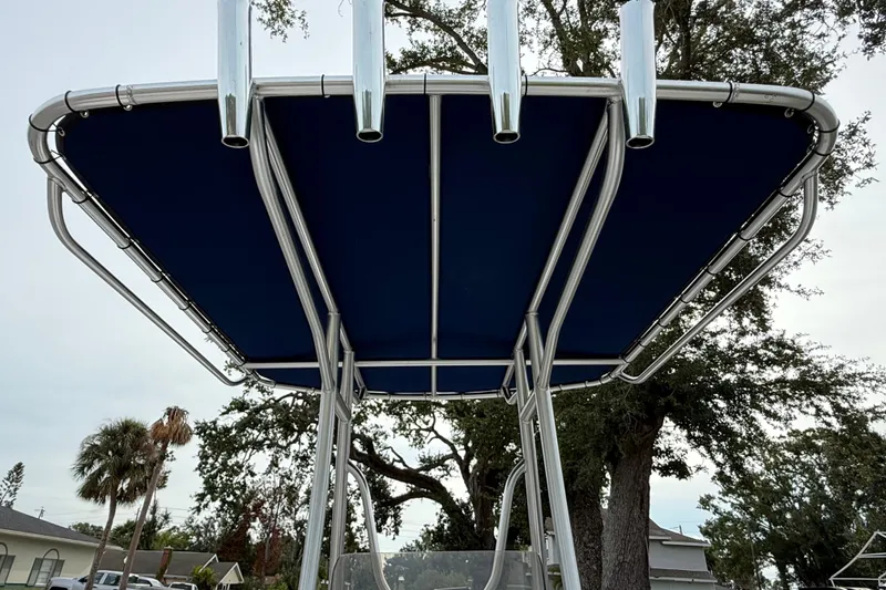 Slide: The Image of 2006 ShearWater Z2200 boat T-top with blue canvas and rod holders. - 26