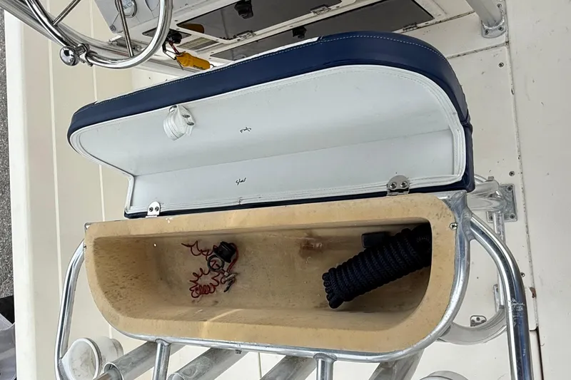 Slide: The Image of Open storage compartment on a 2006 ShearWater Z2200 boat, showing coiled rope and wiring. - 27