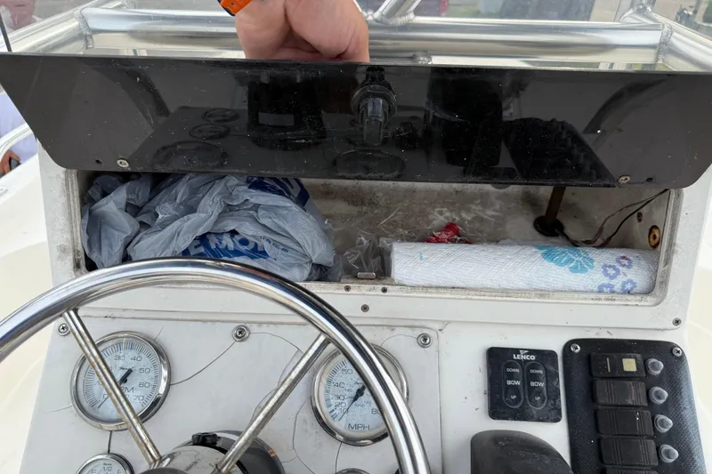 Slide: The Image of 2006 ShearWater Z2200 boat dashboard with storage compartment and steering wheel. - 30