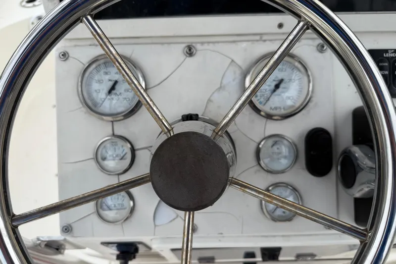 Slide: The Image of Steering wheel and dashboard of 2006 ShearWater Z2200 boat with gauges. - 31