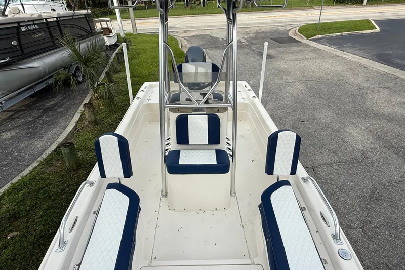 Slide: The Image of 2006 ShearWater Z2200 boat interior with blue and white seating, docked near grass. - 34