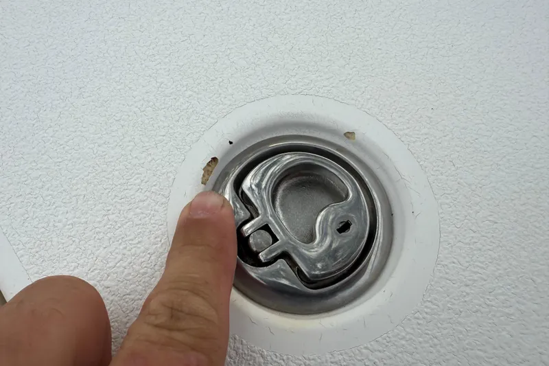 Slide: The Image of Finger pointing at a metal latch on a 2006 ShearWater Z2200 boat. - 39