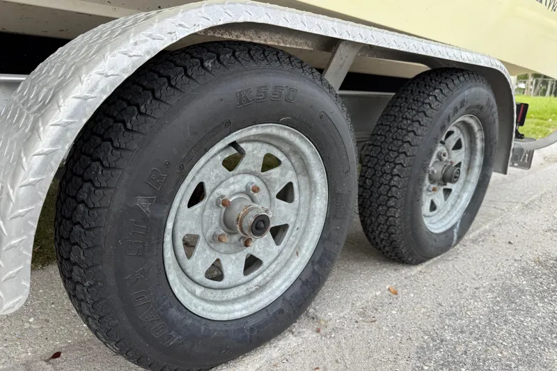 Slide: The Image of Trailer wheels of a 2006 ShearWater Z2200 boat on a textured metal fender. - 44