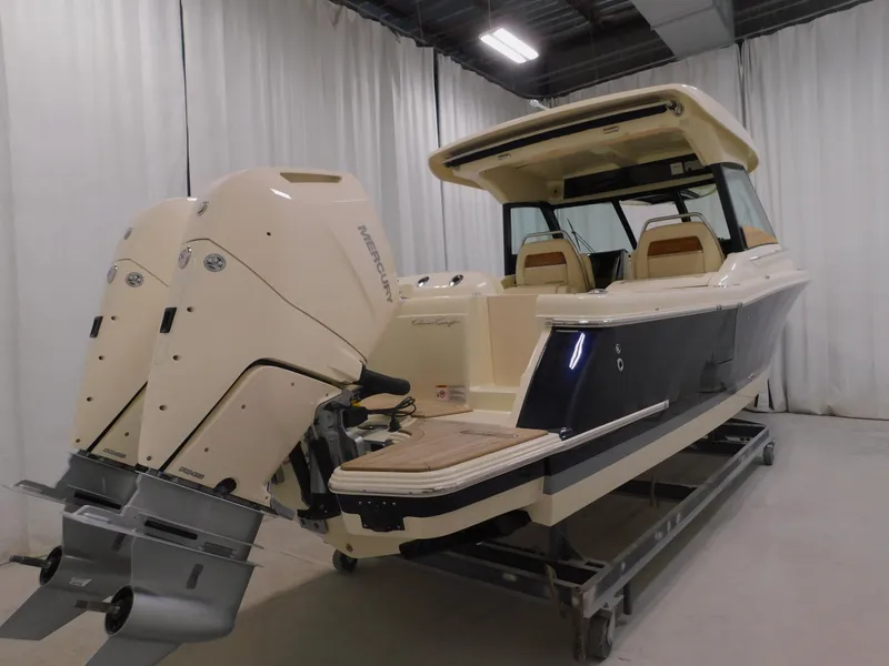 Slide: The Image of 2024 Chris-Craft Calypso 32 boat with twin outboard engines in a showroom. - 5