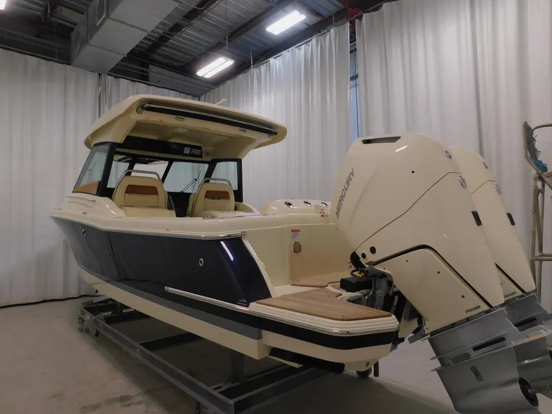 Slide: The Image of 2024 Chris-Craft Calypso 32 boat with dual outboard engines in a showroom. - 8