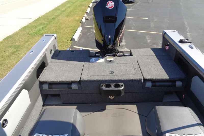 Slide: The Image of 2026 Lund 1975 Tyee boat interior with motor, carpeted deck, and seating. - 10