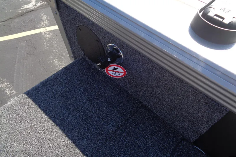 Slide: The Image of Boat interior detail of a 2026 Lund 1975 Tyee with carpeted flooring and a warning sticker. - 23