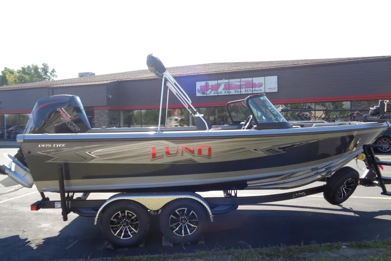 Slide: The Image of 2026 Lund 1975 Tyee boat on trailer, parked outside a marine store. - 27
