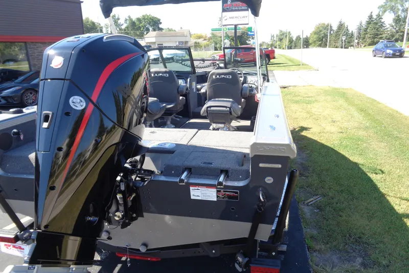 Slide: The Image of 2026 Lund 1975 Tyee boat with powerful outboard motor, parked on grass. - 29