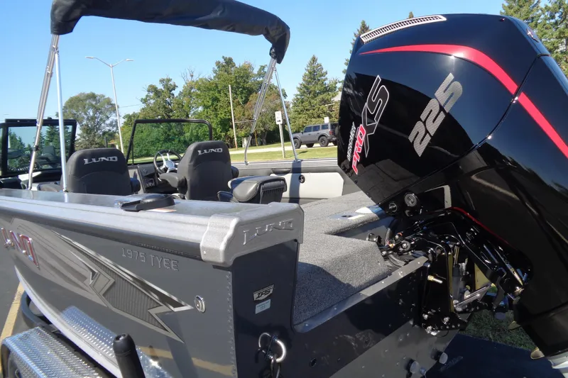 Slide: The Image of 2026 Lund 1975 Tyee boat with powerful 225 Pro XS engine, parked outdoors. - 34