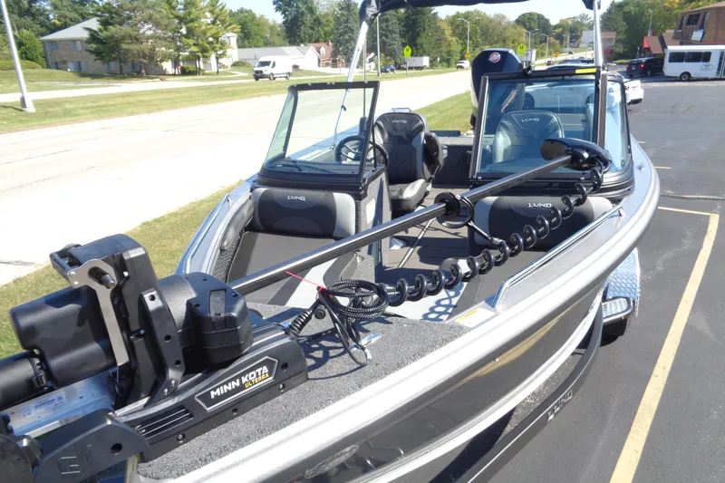 Slide: The Image of 2026 Lund 1975 Tyee boat with Minn Kota motor, parked outdoors on a sunny day. - 6