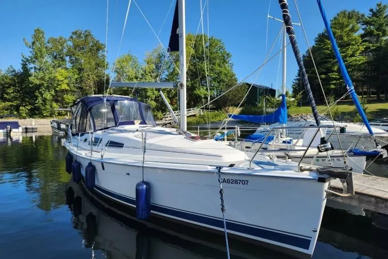 Slide: The Image of 2006 Hunter 33 sailboat docked in a serene marina setting. - 0