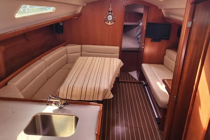 Slide: The Image of Interior of a 2006 Hunter 33 sailboat with cozy seating and wooden finishes. - 11