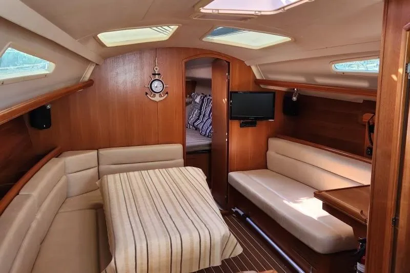Slide: The Image of Interior of a 2006 Hunter 33 sailboat with cozy seating and wooden finishes. - 12