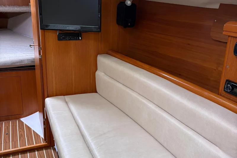 Slide: The Image of Interior of 2006 Hunter 33 sailboat with beige seating and wood paneling. - 13