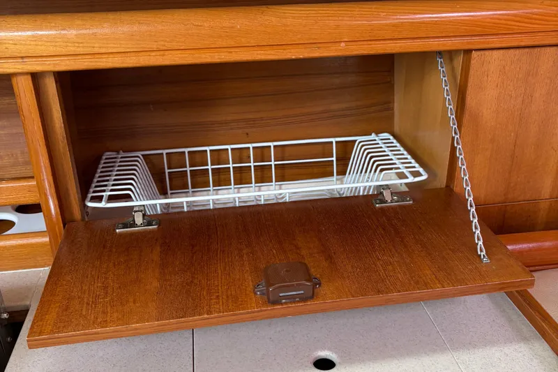Slide: The Image of Wooden cabinet with a drop-down door and wire basket in a 2006 Hunter 33. - 23