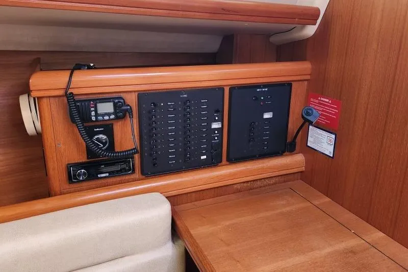 Slide: The Image of Control panel inside a 2006 Hunter 33 sailboat, featuring communication and electrical systems. - 24
