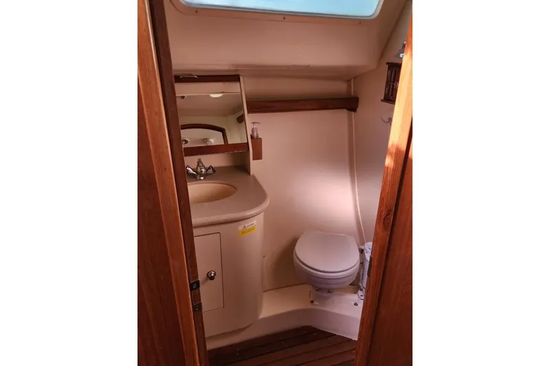 Slide: The Image of 2006 Hunter 33 yacht bathroom with sink, toilet, and wooden accents. - 30