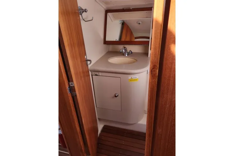 Slide: The Image of 2006 Hunter 33 yacht bathroom with sink, mirror, and wooden accents. - 31