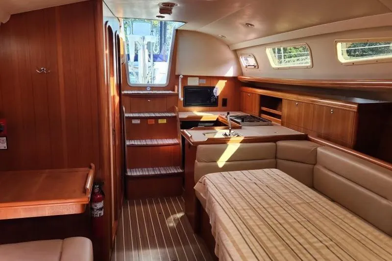 Slide: The Image of Interior of 2006 Hunter 33 sailboat with wood finish and cozy seating area. - 32