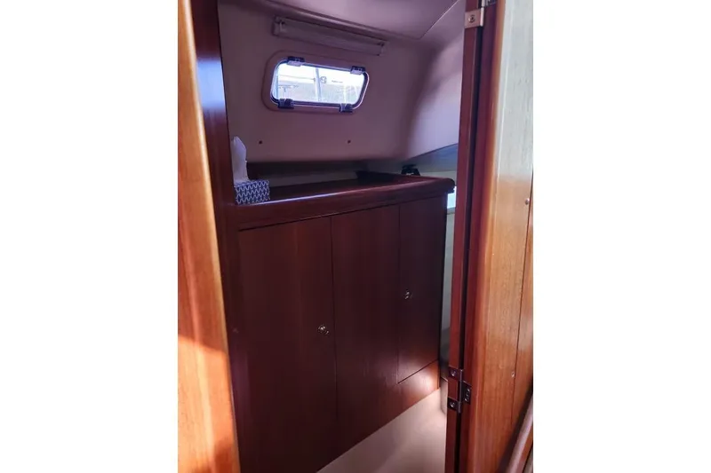 Slide: The Image of Interior cabin of 2006 Hunter 33 sailboat with wooden cabinetry and small window. - 33