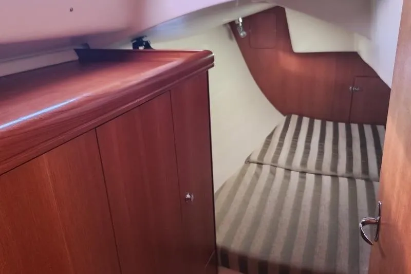 Slide: The Image of Cozy cabin interior of 2006 Hunter 33 sailboat with striped bedding and wooden cabinetry. - 35