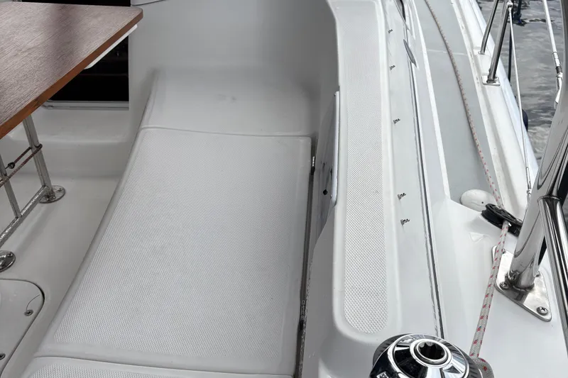 Slide: The Image of Cockpit of 2006 Hunter 33 sailboat with seating and wooden table. - 4