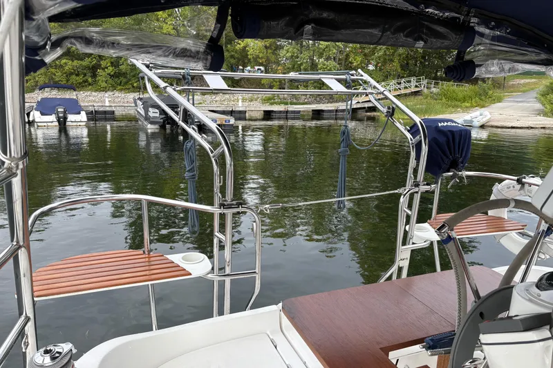 Slide: The Image of Hunter 33 sailboat from 2006 docked at a marina with lush greenery. - 6