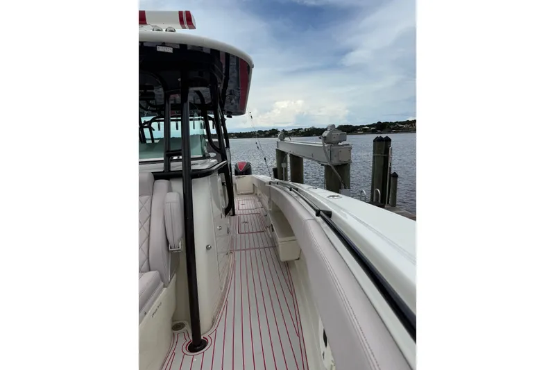 Slide: The Image of 2013 Hydra-Sports 42 boat docked, showcasing sleek design and spacious deck. - 13