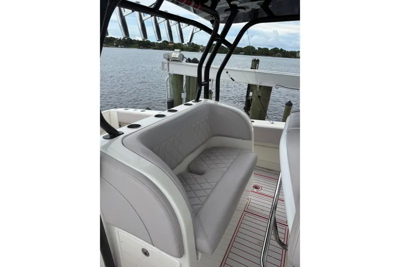 Slide: The Image of 2013 Hydra-Sports 42 boat interior with cushioned seating and rod holders by the water. - 17