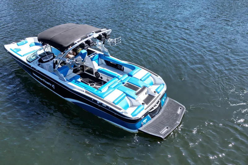 Slide: The Image of 2017 MasterCraft X26 boat with blue and white seating on calm water. - 11