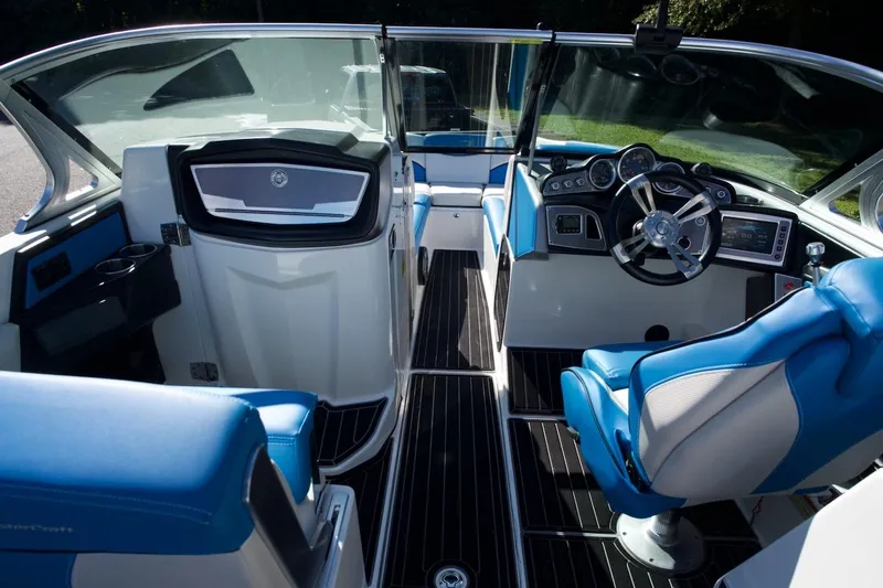 Slide: The Image of 2017 MasterCraft X26 boat interior with blue and white seating, modern dashboard, and steering wheel. - 13