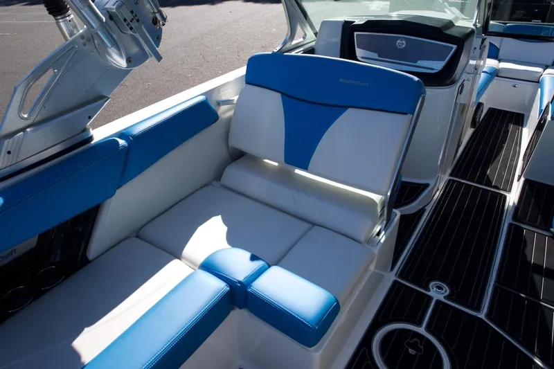 Slide: The Image of 2017 MasterCraft X26 boat interior with blue and white seating and sleek dashboard design. - 16
