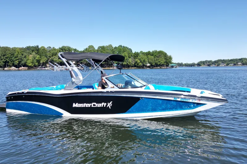 Slide: The Image of 2017 MasterCraft X26 boat on a lake with trees in the background. - 7