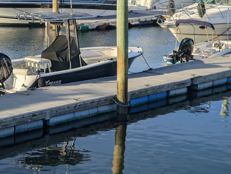Slide: The Image of 2017 Mako 204 Center Console boat docked at marina, calm water reflections. - 20