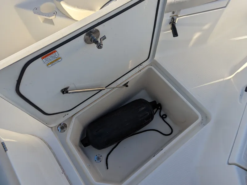 Slide: The Image of Open storage compartment on 2017 Mako 204 Center Console boat with black fender inside. - 8