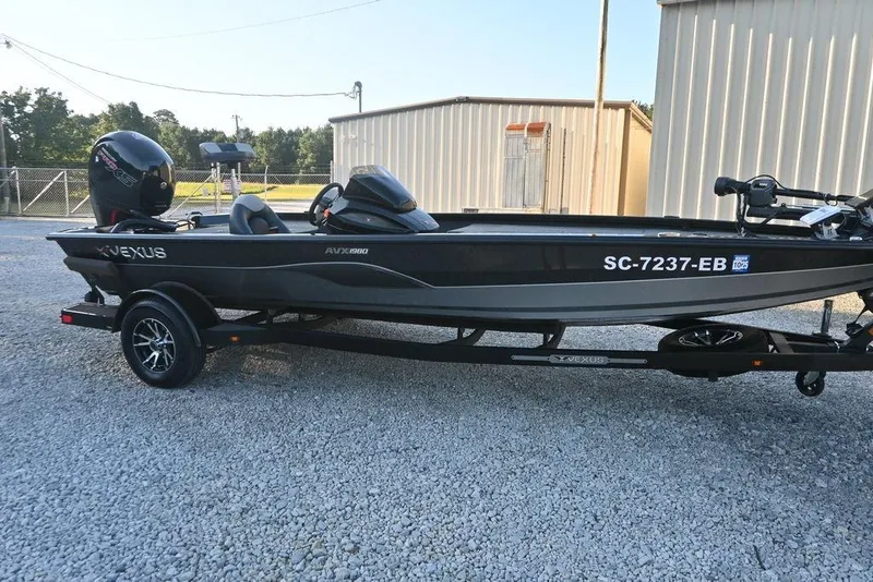 Slide: The Image of 2022 Vexus AVX1980 boat on trailer, parked on gravel near metal building. - 3