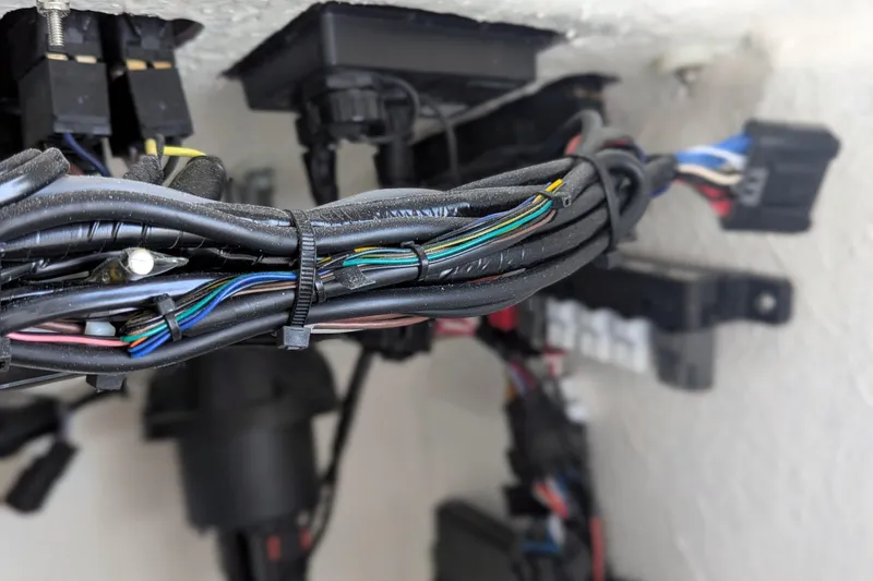 Slide: The Image of 2026 BlackJack 224 boat with sleek white console and seating, parked near a street. - 12