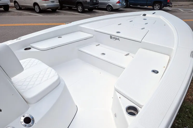 Slide: The Image of Open storage compartment on 2026 BlackJack 224 boat with white cushioned seating. - 16