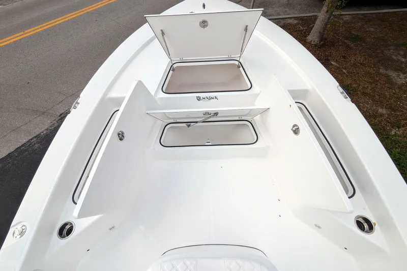 Slide: The Image of 2026 BlackJack 224 boat interior with white seating and storage compartment. - 19