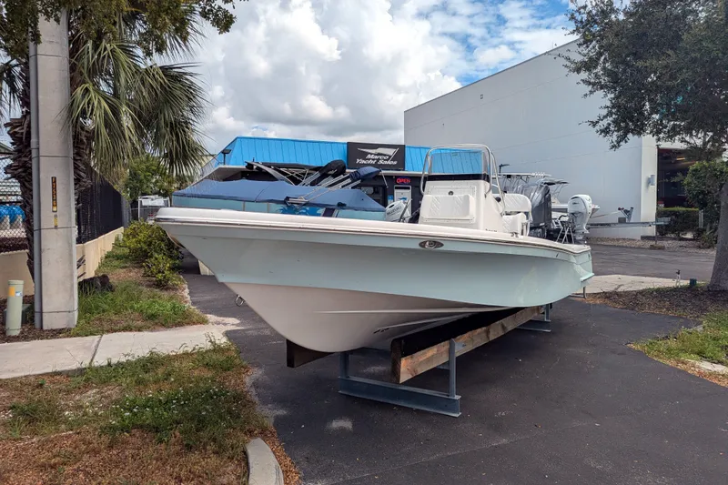 Slide: The Image of 2026 BlackJack 224 boat displayed outdoors at a dealership, surrounded by trees and buildings. - 30