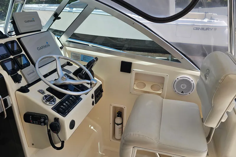 Slide: The Image of 2004 Pursuit 3070 Express boat cockpit with Garmin navigation system and steering wheel. - 10