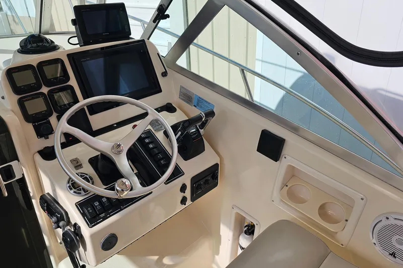 Slide: The Image of 2004 Pursuit 3070 Express boat cockpit with steering wheel and navigation controls. - 11
