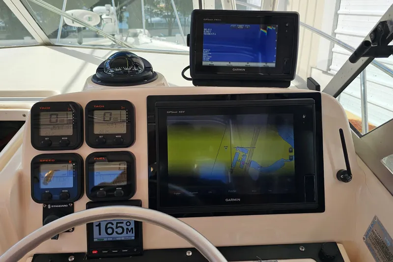 Slide: The Image of Dashboard of a 2004 Pursuit 3070 Express boat with Garmin navigation displays. - 12