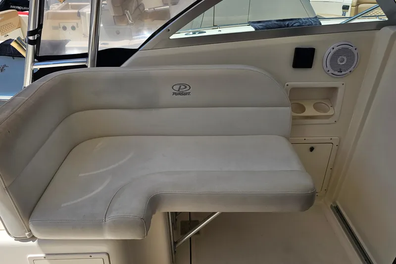 Slide: The Image of 2004 Pursuit 3070 Express boat interior seating with cup holders and speaker. - 13