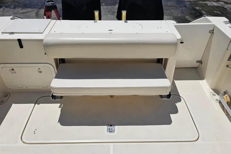 Slide: The Image of 2004 Pursuit 3070 Express boat interior with foldable bench seat and storage compartments. - 19