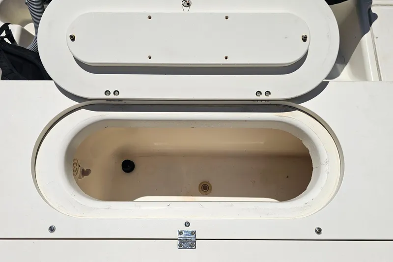 Slide: The Image of Open storage compartment on 2004 Pursuit 3070 Express boat, showing interior details. - 21