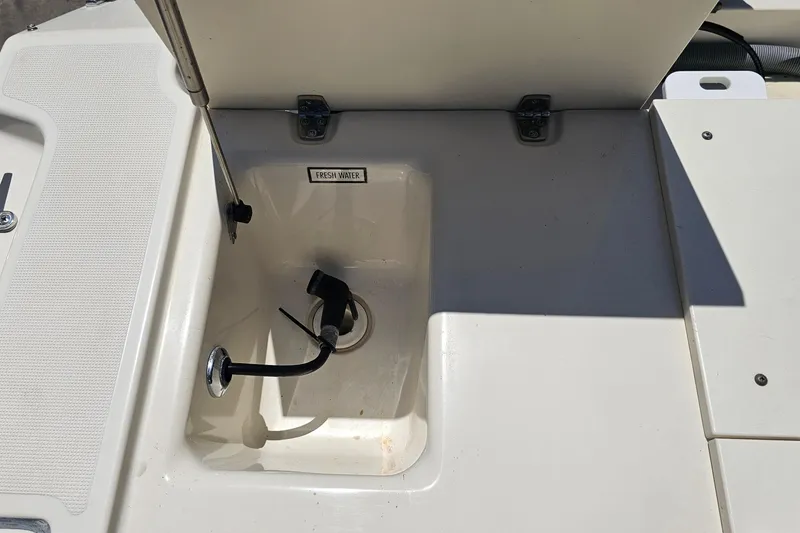 Slide: The Image of Freshwater compartment on 2004 Pursuit 3070 Express boat, featuring a faucet and drain. - 22
